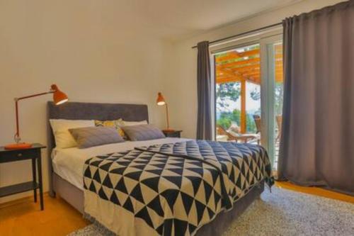 a bedroom with a bed and a large window at Seaside Penthouse HighLife in Ivan Dolac