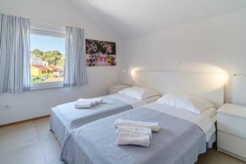 two beds in a white room with towels on them at Villa Ameli in Milna