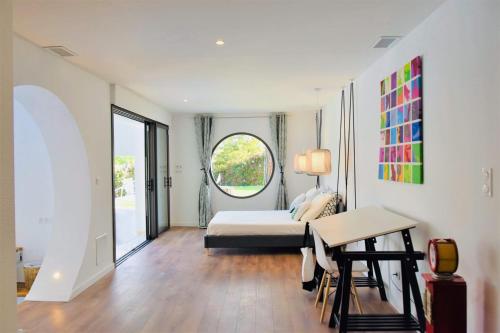 een slaapkamer met een bed, een tafel en een raam bij La P.Dwelling Luxury House in Saint-Raphaël