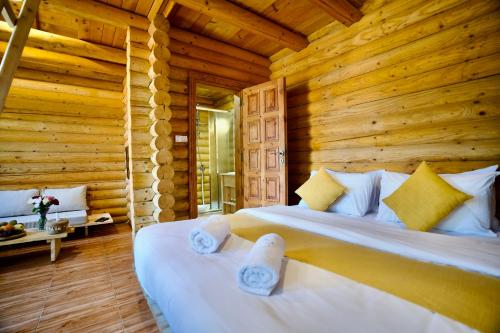 a bedroom with a bed in a log cabin at Wood Hills Hotel & Resort in Mayrūbā