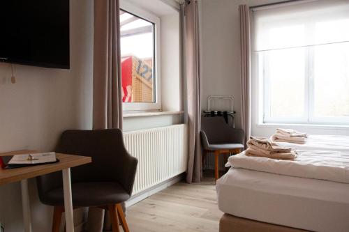 Zimmer mit einem Bett, einem Schreibtisch und einem Fenster in der Unterkunft Hotel Seebrise Grömitz in Grömitz