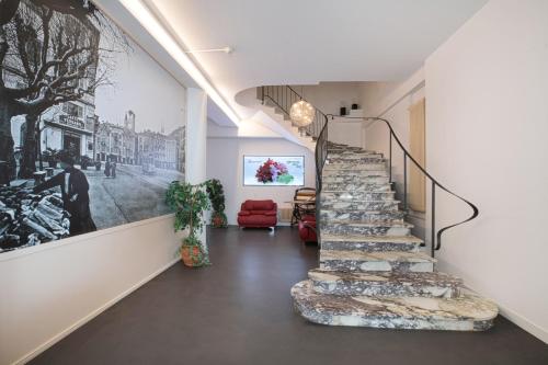 a staircase in a house with a painting on the wall at Hotel Geranio Au Lac in Locarno