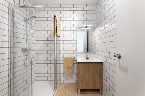 een witte badkamer met een wastafel en een douche bij LaResiBCN minimum 30 nights in Barcelona