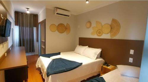 una camera d'albergo con letto e TV di Itaverá Master Hotel a Presidente Prudente