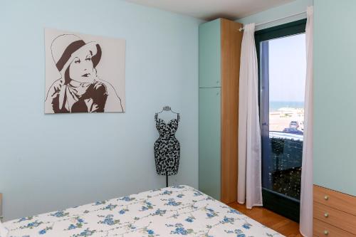 a bedroom with a bed and a picture of a cowboy at SE065 - Senigallia, meraviglioso bilocale sul mare in Senigallia