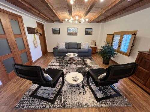 uma sala de estar com um sofá e duas cadeiras em Cal Campana em Gratallops