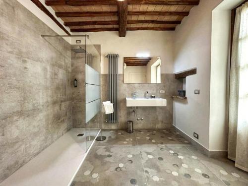 La salle de bains est pourvue d'une douche en verre et d'un lavabo. dans l'établissement CasalPiano, à Orvieto