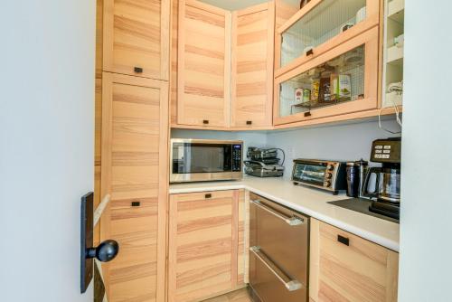 a kitchen with wooden cabinets and a microwave at Sausalito Oasis - 3 Mi to Golden Gate Bridge! in Sausalito