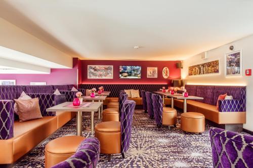a restaurant with purple furniture and tables and chairs at CityClass Hotel Alter Markt in Cologne