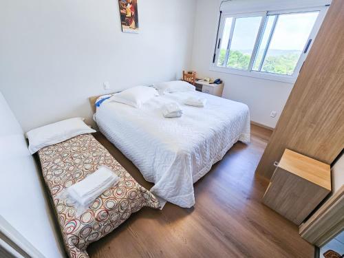 a small bedroom with a bed and a window at Pousada Bom Pastor in Caxias do Sul