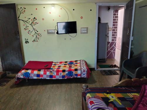 a room with a bed and a tv on the wall at Coorg Kusuma's budget homes in Madikeri