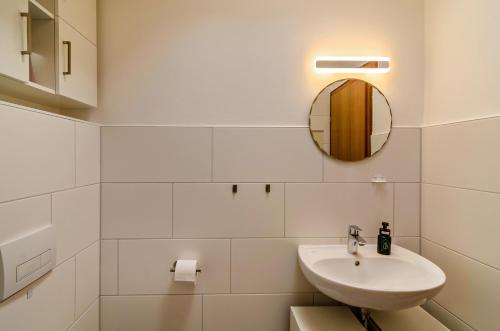 a white bathroom with a sink and a mirror at Ferien Bei Familie Martin in Bad Zwischenahn