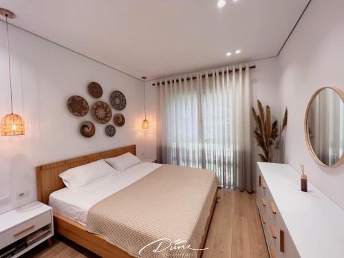 a white bedroom with a bed and a mirror at Dune Apartments, San Pietro Resort in Lalëz