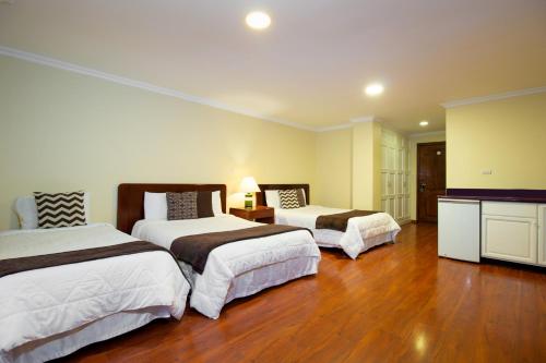 a hotel room with two beds and a television at Hotel NASS Pinar del Lago in Cuenca
