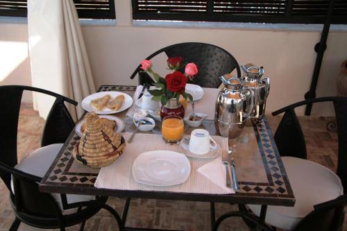a table with breakfast foods and flowers on it at Riad Diana in Marrakech