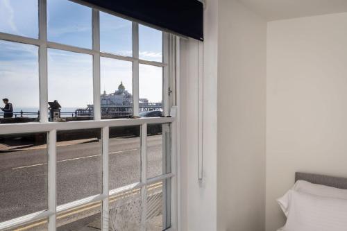 Cette chambre dispose d'une fenêtre offrant une vue sur un bâtiment. dans l'établissement Promenade View - seafront hideaway, à Eastbourne