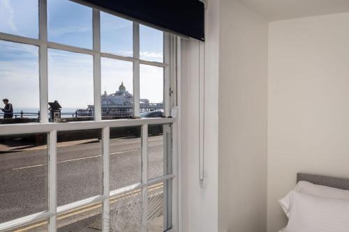 a room with a window with a view of a building at Promenade View - seafront hideaway in Eastbourne