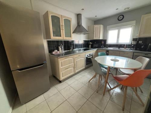 une cuisine avec une table, des chaises et un réfrigérateur dans l'établissement Maison individuelle 6-8 couchages avec garage, à Vendin-le-Vieil