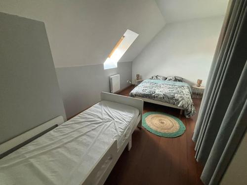 Cette petite chambre comprend deux lits et un matelas. dans l'établissement Maison individuelle 6-8 couchages avec garage, à Vendin-le-Vieil