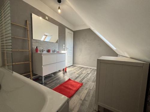 La salle de bains est pourvue d'une baignoire blanche et d'un tapis rouge. dans l'établissement Maison individuelle 6-8 couchages avec garage, à Vendin-le-Vieil