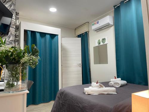 een slaapkamer met blauwe gordijnen en handdoeken op een bed bij Storico17 in Catania
