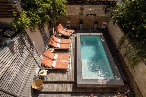 een uitzicht over een zwembad op een terras bij Hôtel la Maison de Rhodes & Spa in Troyes