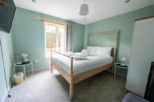 a bedroom with a bed with blue walls and a window at Aaron Wise - 17 Fitzhamon Apartments in Cardiff
