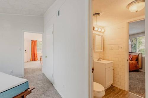 ein weißes Bad mit einem WC und einem Waschbecken in der Unterkunft Groovy Getaway Centrally Located in Augusta