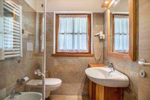 a bathroom with two sinks and a toilet at Chalet Camping Faè 1 in Madonna di Campiglio