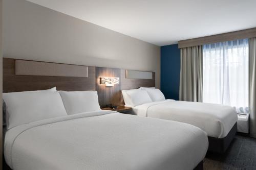 a hotel room with two beds and a window at Holiday Inn Express Savannah Airport by IHG in Savannah