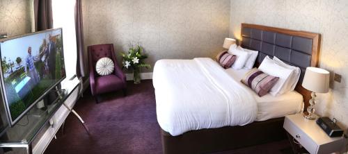 a hotel room with a bed and a flat screen tv at Best Western Red Lion Hotel in Salisbury