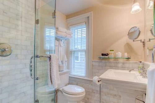 a bathroom with a toilet and a sink and a shower at Portland's White House Carriage House in Portland
