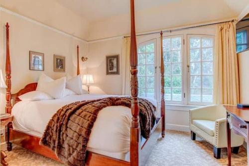 a bedroom with a bed and a desk and window at Portland's White House Carriage House in Portland