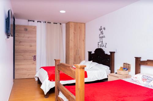 a bedroom with two beds and a red rug at HOTEL Y RESTAURANTE SHALOM in Pamplona