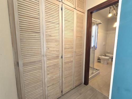 a bathroom with a toilet and a wooden closet at Chez Choucas Maison e Maisonette - Goelba in Portoferraio