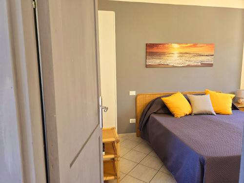 a bedroom with a bed with yellow pillows at Chez Choucas Maison e Maisonette - Goelba in Portoferraio