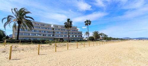 un edificio su una spiaggia con palme di fronte di Apartamento Marenia by DENIA COSTA a Denia