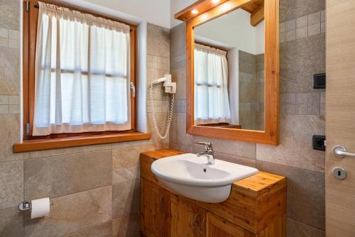 a bathroom with a sink and a mirror at Chalet Camping Faè 3 in Madonna di Campiglio