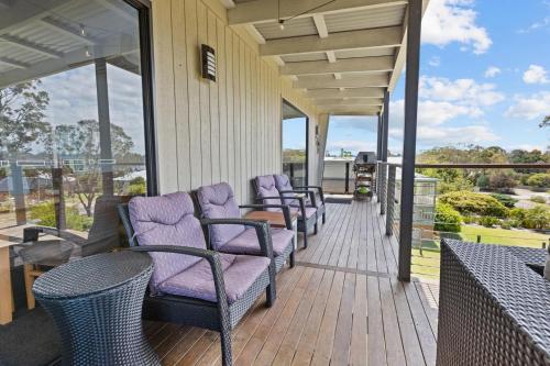 a porch with chairs and tables on a balcony at Elevation in Paynesville