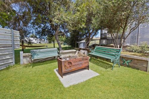 two park benches and a sign in the grass at Elevation in Paynesville