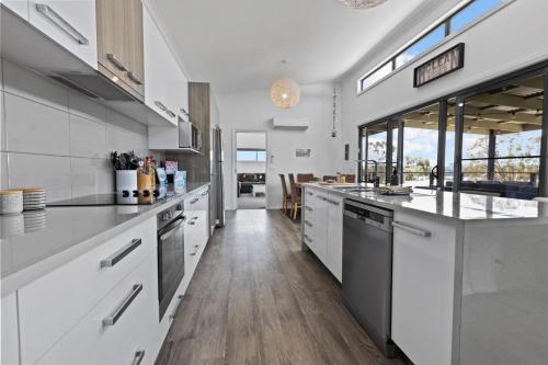 a large kitchen with white cabinets and a counter top at Elevation in Paynesville