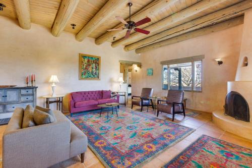 uma sala de estar com um sofá e uma televisão em Taos Adobe Home with Mountain Views and Hot Tub! em Taos
