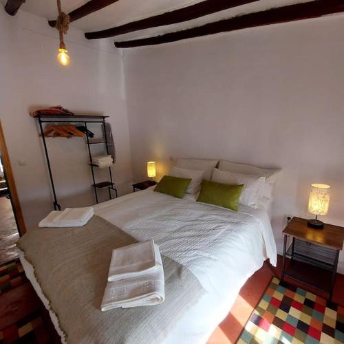 a bedroom with a large white bed with green pillows at Cozy Townhouse in Algodonales