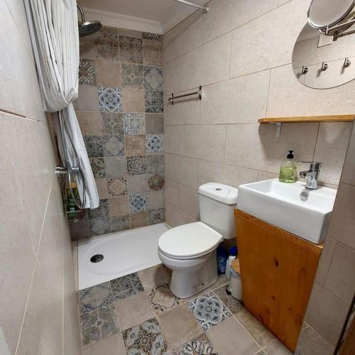 a bathroom with a white toilet and a sink at Cozy Townhouse in Algodonales