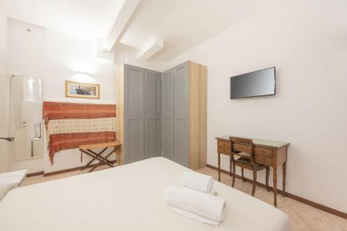 - une chambre avec un lit, un bureau et une télévision dans l'établissement Casa Luna - vicino alla stazione dei treni, à Venise