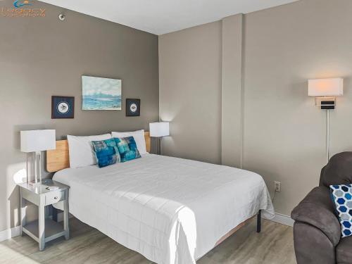 a bedroom with a large white bed with blue pillows at PB B204 - Close to Beach - Optional Boat Slip in Fort Walton Beach