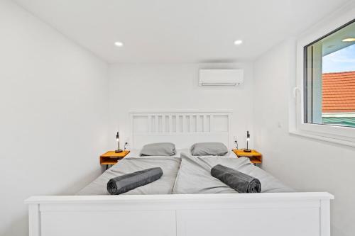 a white bedroom with a bed and a window at Villa Jäger mit Pool in Wien in Vienna