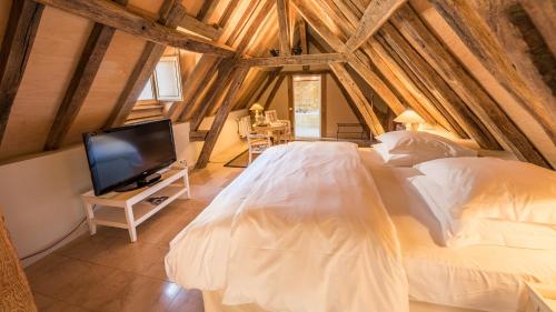 two white beds in a room with a tv at La Maison de Rhodes Hôtel & Spa in Troyes