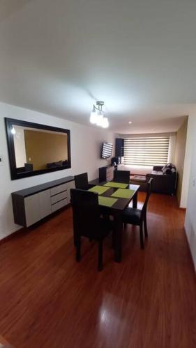 a living room with a table and chairs and a television at Hermoso departamento mejor ubicación Modelia Bta. in Bogotá