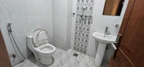 a bathroom with a toilet and a sink at Hotel Simara in Simra